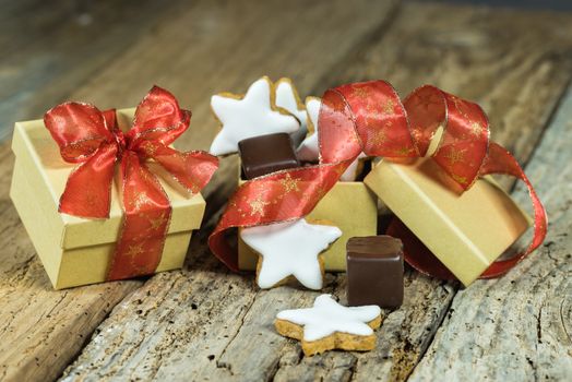 Sweet christmas gift with star biscuits and chocolate on wooden table
