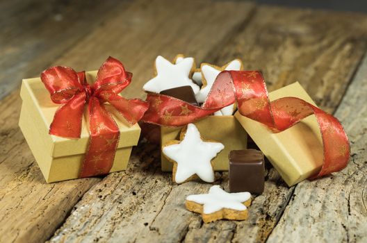 Sweet Christmas present with star biscuits and chocolate on old table