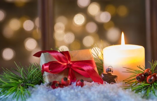 Xmas season decoration with christmas present and candlelight on snow