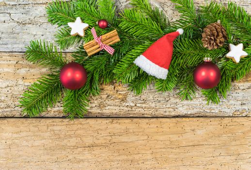 Christmas composition with ornaments and fir branch on rustic wood, copy space