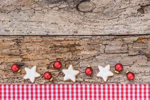 Christmas border with ornaments on rustic wood background, top view