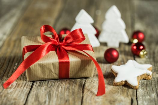 Christmas gift box with decorations on wood