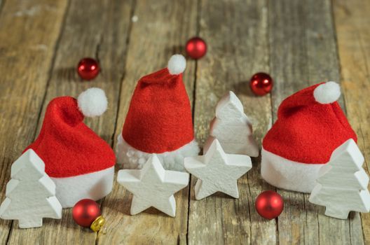 Santa Claus caps with red and white christmas decoration on wood background