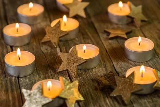 Advent and Christmas candle flames with golden star decoration on wooden table
