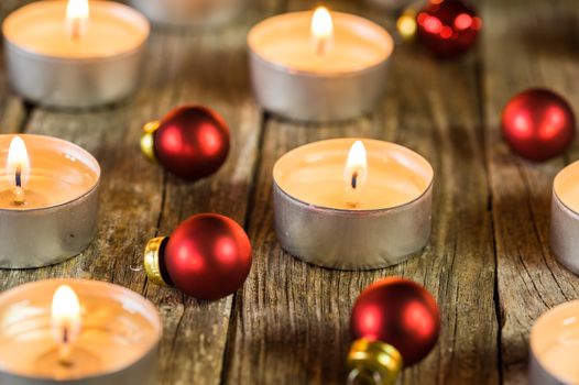 Festive Christmas mood with candles and red baubles decorations