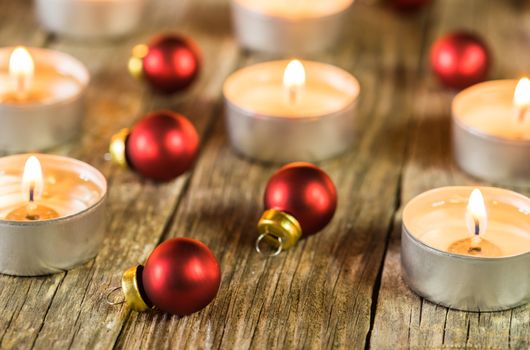 Advent and Christmas candlelights with red balls on wooden table