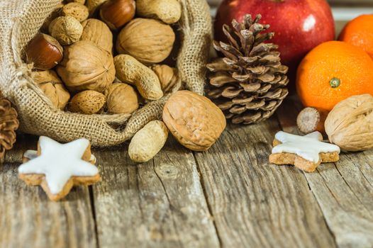 Christmas food composition of nuts in santa claus sack, star shape cookies and fruits