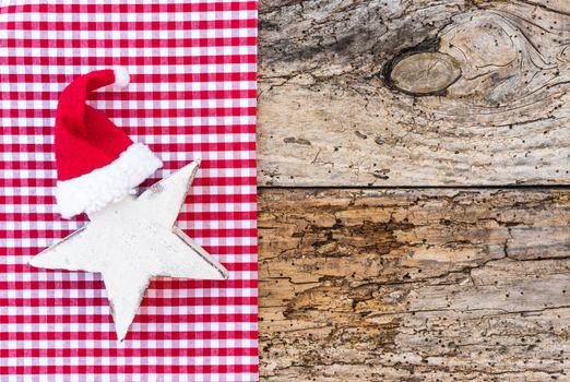 Rustic Christmas background decoration with white star shape and red santa claus hat, copy space