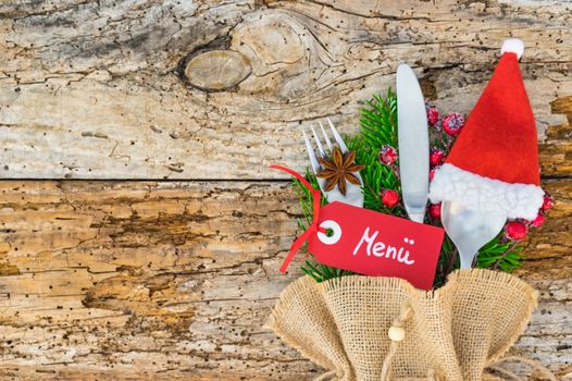 Christmas or Advent dinner table place setting with cutlery and red santa decoration