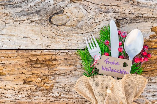 Christmas table place setting with  tag in german text, Frohe Weihnachten, means Merry Christmas