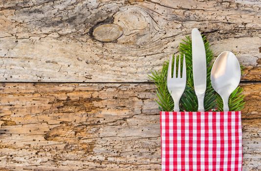 Christmas dinner table place setting on rustic wood background, copy space