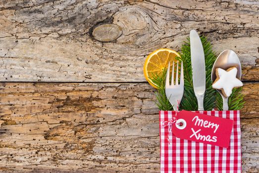 Christmas table place setting, rustic wooden background, copy space, label Merry Xmas