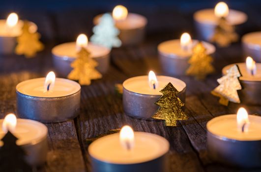 Christmas or advent candles with ornaments on wooden background