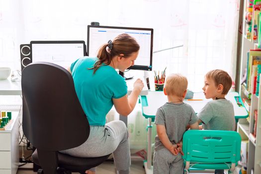 Mother with kids trying to work from home during quarantine. Stay at home, work from home concept during coronavirus pandemic