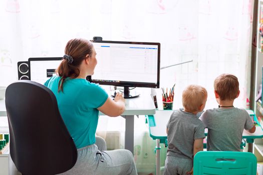 Mother with kids trying to work from home during quarantine. Stay at home, work from home concept during coronavirus pandemic