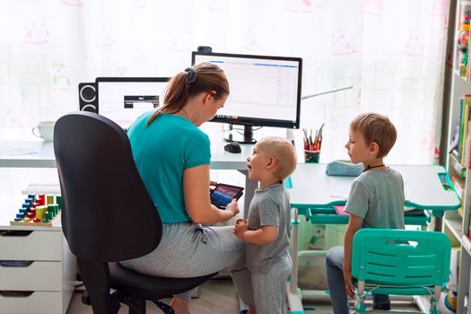 Mother with kids trying to work from home during quarantine. Stay at home, work from home concept during coronavirus pandemic