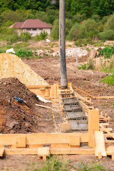 Lay of the cement or concrete into the foundation formwork with automatic pump. Building house foundation