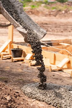 Lay of the cement or concrete into the foundation formwork with automatic pump. Building house foundation