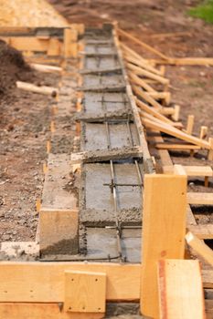 Lay of the cement or concrete into the foundation formwork with automatic pump. Building house foundation