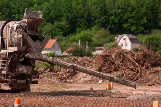 Lay of the cement or concrete into the foundation formwork from concrete mixer. Building house foundation