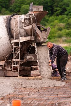 Lay of the cement or concrete into the foundation formwork from concrete mixer. Building house foundation