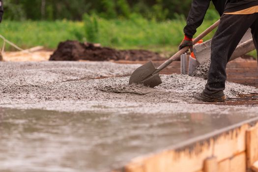 Lay of the cement or concrete into the foundation formwork from concrete mixer. Building house foundation