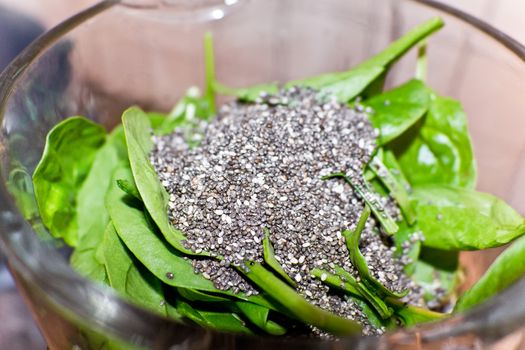 Healthy food. Chia seeds and spinach leaves mixed together in a bowl as ingredients.