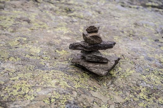 Stacked stones for trekking route in Norwegian landscape on rocks.