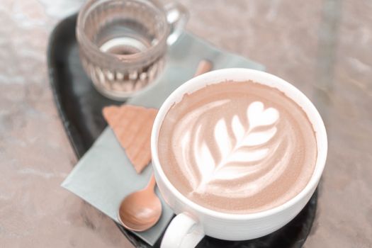 Closeup glass of latte art coffee tulip shape on wood background with vintage color, selective focus