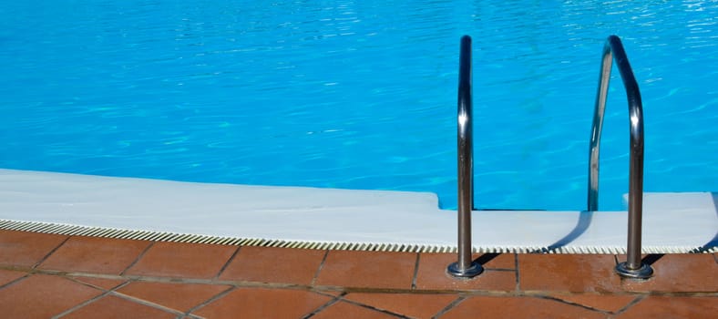 Swimming pool with grab bars ladder background. Summer concept.