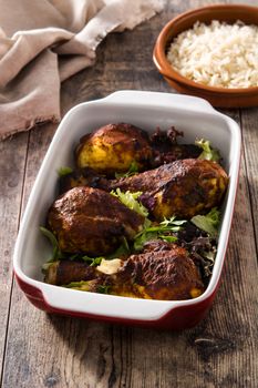 Roasted tandoori chicken with basmati rice on wooden table