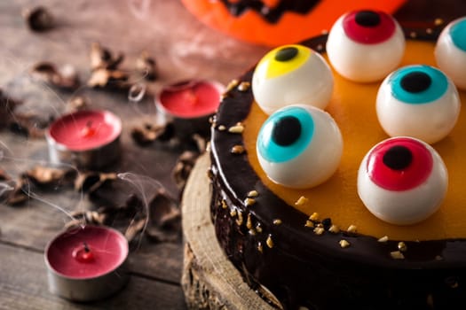 Halloween cake with candy eyes decoration on wooden table
