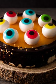 Halloween cake with candy eyes decoration on wooden table