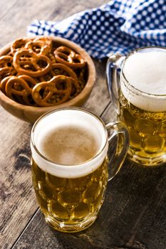 Oktoberfest beer and pretzel on wooden table.