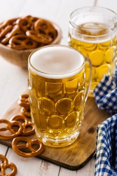 Oktoberfest beer and pretzel on wooden table.