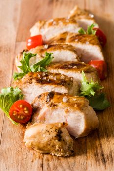 Grilled chicken breast with vegetables on wooden table