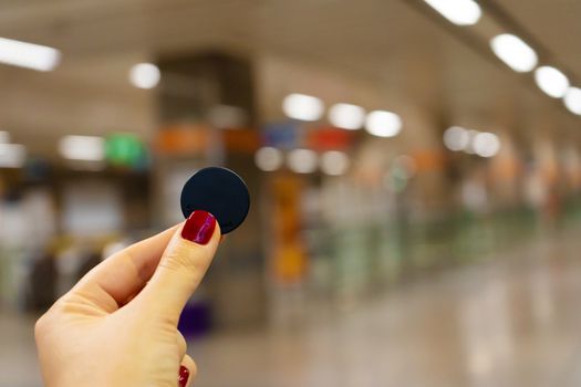 A girl holds a token for a pass in the Bangkok subway. Bangkok public transport