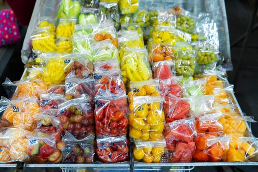 Street food market in Asia. Fruit packaged in mini plastic bags. Takeaway Fruit Snack.