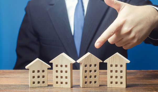 A man chooses an apartment house among many propositions options in the real estate market. Housing solution. Facilities and infrastructure. Investments. Realtor services to find suitable options.