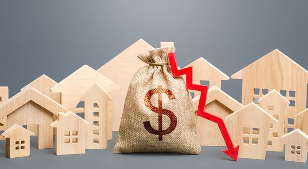 City residential buildings and dollar money bag with a red down arrow. Low cost of real estate. Lower mortgage interest rates. Falling prices for rental apartments. Reducing demand for home buying