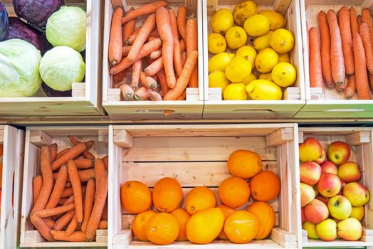 Fruits and vegetables in wooden boxes for sale at a market