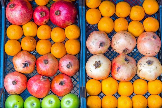 Oranges, apples and pomegranates for sale at a market