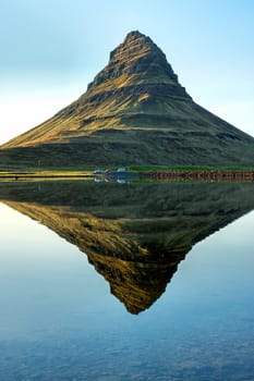 The famous Mount Kirkjufell in Iceland reflects in a small lake
