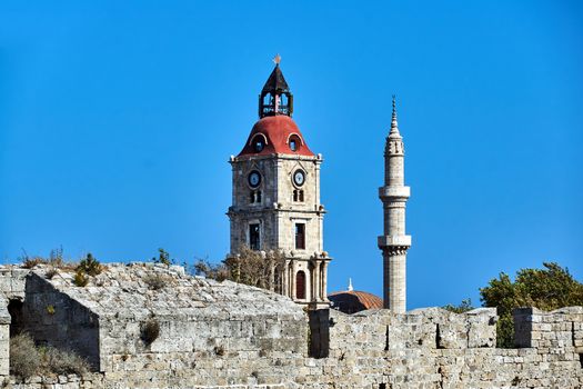 Stone Tower and Turkish minaret behind the medieval defensive wall in Rhodes