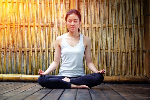 Young beautiful woman meditating in nature bamboo backgroud