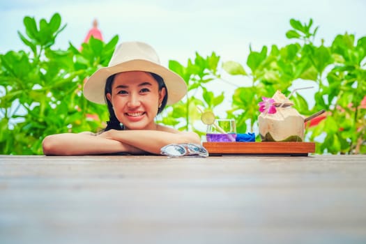 Happy woman with fresh coconut water on the beach