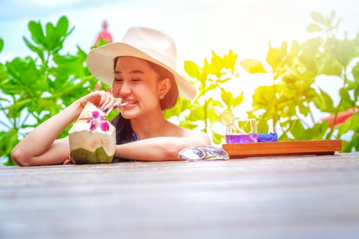 Happy woman with fresh coconut water on the beach