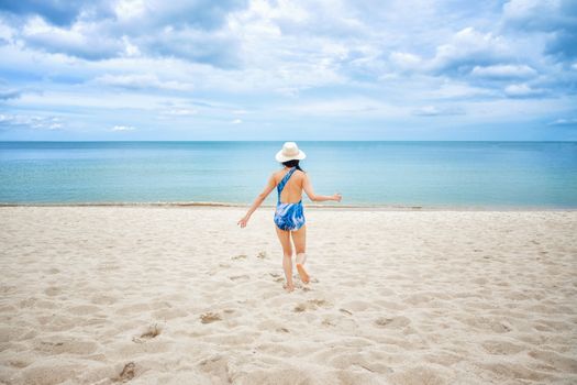 Young happy woman running on the beach 