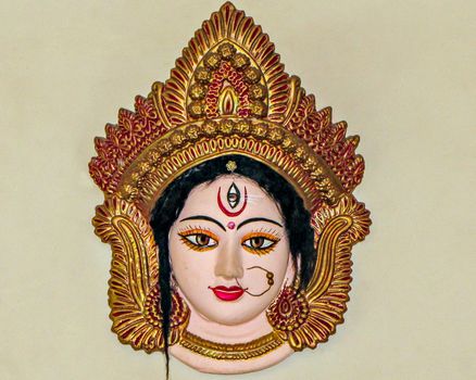 Precisely crafted, painted and decorated face of Godess Durga , hanging on a wall.