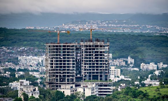 Twin, tall buildings under construction in Pune, Maharashtra, India. New infrastructure under developement.